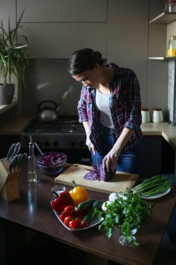 Mutfakta çalışan güzel esmer. Kadın sebzeleri keser. Vejetaryen ve sağlıklı yaşam tarzı.