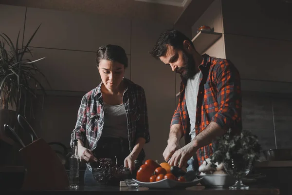 Güzel genç çift mutfakta yemek sağlıklı yemek sırasında evde. Koca lahana kesti. Karısı karışımı salata. Olay yerinden aile hayatı. — Stok fotoğraf