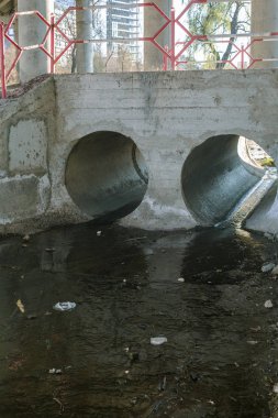 Köprünün altında iki beton kanalizasyon borusu var. Siyah kirli su.
