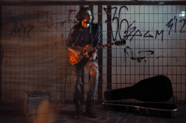 Bir sokak müzisyen alt geçit gitar oynuyor. Vagrant yaşam tarzı. Yaşam yapmak için alt geçit içinde oynuyor. İşsiz müzisyen. Geleceğin rock yıldızı.
