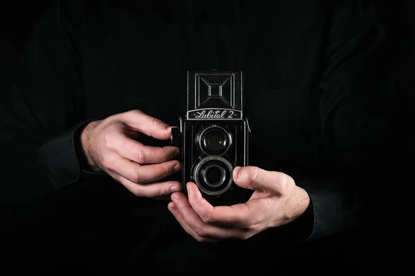 Chisinau, Republic of Moldova - March 12, 2019: A man photographer holds the retro photo camera Lubitel-2, medium format twin-lens reflex camera manufactured by LOMO factory, Russia Leningrad. — Stock Photo, Image