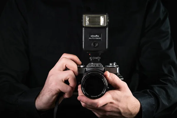 Chisinau, Republic of Moldova - March 12, 2019: Man photographer holding a camera. Shooting process. Japan retro photo camera Minolta and flash Minolta. — Stock Photo, Image