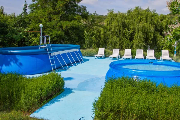 Recreación y zona de baño. Dos piscinas inflables y tumbonas . — Foto de Stock