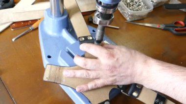 Ana basın ile cilt üzerinde çalışıyor. Araçları ve aksesuarları ile dağınık kahverengi ahşap masa.