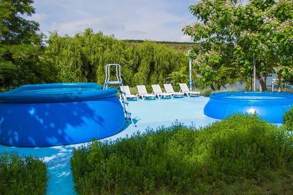 Rekreation och badplats. Två uppblåsbara pooler och solstolar. — Stockfoto