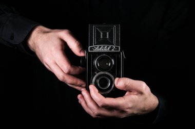 Chisinau, Moldova Cumhuriyeti - Mart 12, 2019: Bir adam fotoğrafçı retro fotoğraf makinesi Lubitel-2, lomo fabrikası, Rusya Leningrad tarafından üretilen orta format ikiz lensli refleks kamera tutar.