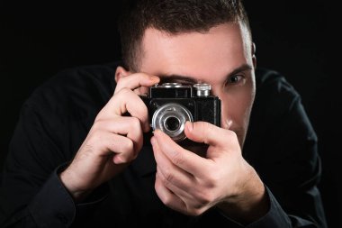 Retro fotoğraf makinesi tutan adam fotoğrafçı. Çekim işlemi. Fotoğrafçı vizör bakar.