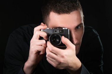 Retro fotoğraf makinesi tutan adam fotoğrafçı. Çekim işlemi. Fotoğrafçı vizör bakar.