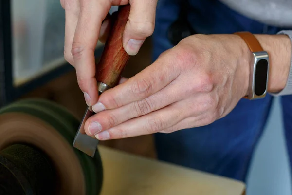 Близько до шкіряного майстра гострий ніж для різання шкіри на шліфувальній машині. Концепція ручної роботи. Концепція малого бізнесу для створення шкіряних виробів . — стокове фото