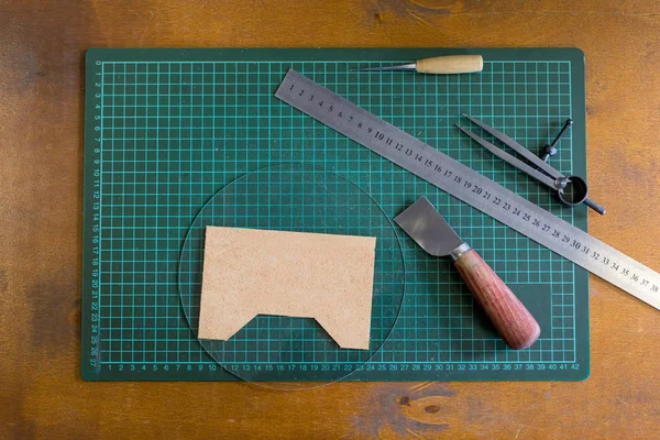 Un ensemble d'outils pour travailler le cuir sur une table en bois. Concept fait main. Concept de petite entreprise pour créer des produits en cuir . — Photo