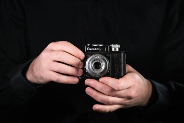 Chisinau, Moldova Cumhuriyeti - 12 Mart 2019: Elinde kamera olan adam fotoğrafçı. Çekim işlemi. Rus retro fotoğraf makinesi Smena 2.