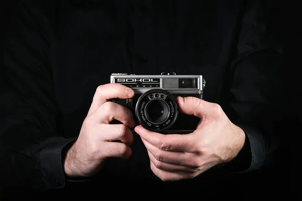 Chisinau, Republic of Moldova - March 12, 2019: Man photographer holding a camera. Shooting process. Russian retro photo camera Sokol. — Stock Photo, Image