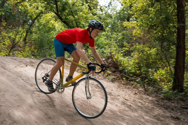 Um ciclista monta em uma bicicleta de estrada, descendo colina . — Fotografia de Stock