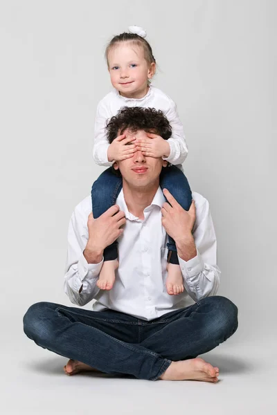 Fadern håller sin dotter på axlarna. Flickan stängde ögonen. Konceptet Happy föräldraskap och Happy Childhood. På vit bakgrund. — Stockfoto