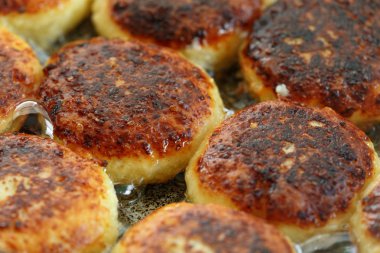 Tavada lezzetli kızarmış syrniki closeup pişirme işlemi. Ukrayna, Beyaz Rusya ve Rusya'da geleneksel. Sağlıklı bir ev yemeği kavramı.