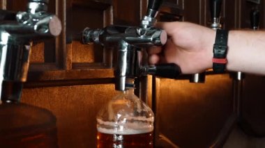 Plastik şişeye bira döken adam. Bira şişeleme tesisi. Barman tavernada hizmet vermektedir.