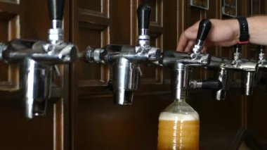 Adam plastik bir şişeye bira dökmeye. Bira şişeleme tesisi. Barmen tavernada hizmet vermektedir. Yavaş hareket.