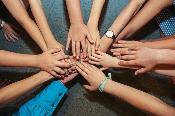 Primo piano di molte mani di bambini che tengono insieme come una squadra su uno sfondo naturale . — Foto Stock