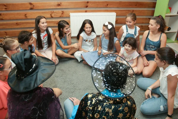 Chisinau, República da Moldávia - 23 de julho de 2019: um grupo de garotas se senta em um círculo e ouve os animadores . — Fotografia de Stock