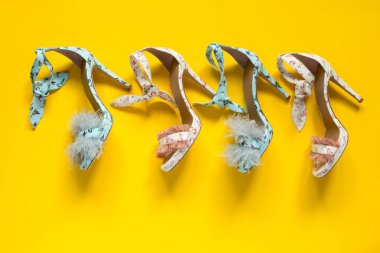 Yaz kadın yüksek topuklu ayakkabılar. Flamingo sinekkuşları ve tüyleri. Sarı kağıt arka plan.