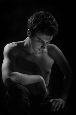 Genç bir adamın portresi. Siyah arka planda.