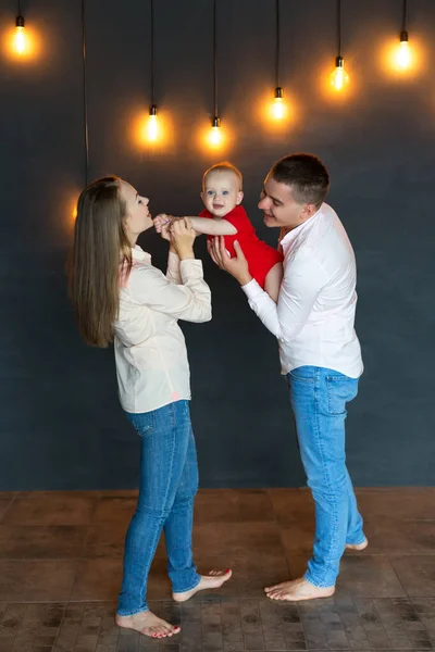 Rodzice bawią się i pobłażają dziecku. Mama, tata i dziecko. Portret młodej rodziny. Szczęśliwego życia rodzinnego. Człowiek się urodził.. — Zdjęcie stockowe