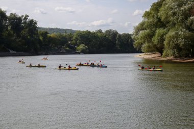 Bir grup kayakçı nehir boyunca yüzer. Yatay çerçeveli çekim.