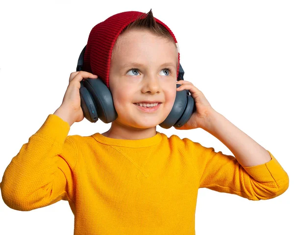 ヘッドフォンを持つ子供 ヘッドフォンで音楽を聴いている美しいヨーロッパの少年 見上げます 子供の頃から音楽好き — ストック写真