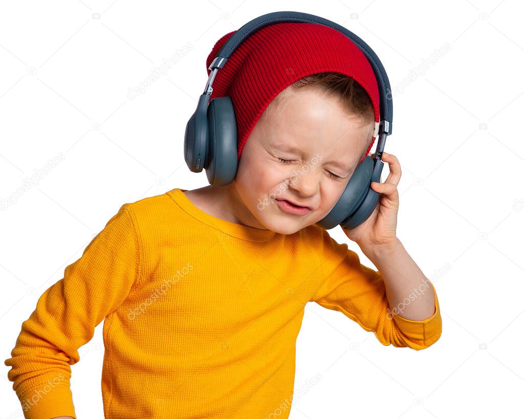 A child with headphones. A beautiful European boy listens to music with headphones, dances, enjoys, gets high. The boy squints with pleasure. Music lover since childhood. DJ.