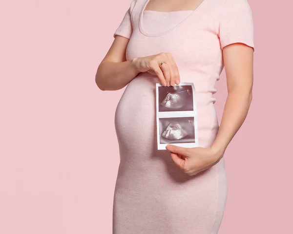 Figure of a pregnant woman at 22 weeks of pregnancy with an ultrasound image. A mother waiting for a child. Pregnancy and childbirth. Medical supervision during pregnancy.