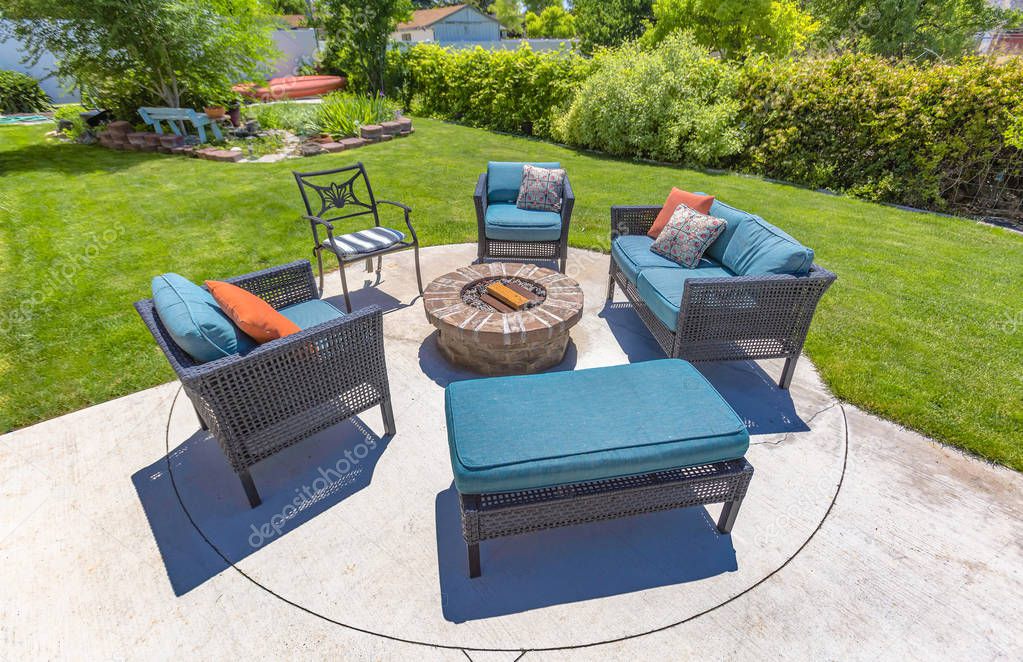 Chairs around a circular fire pit in the backyard