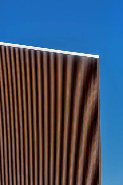 Brown metal panels and silver lining with blue sky