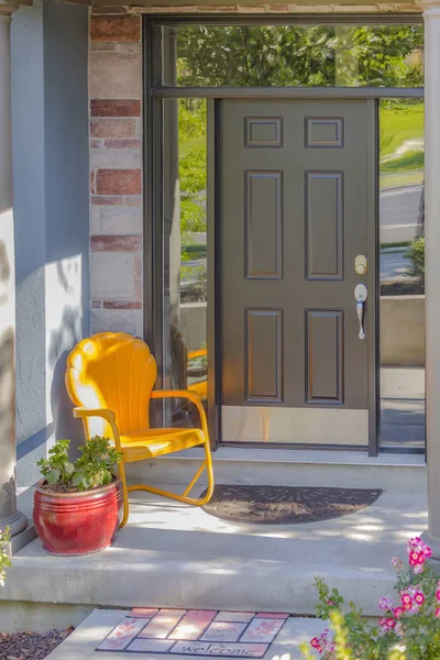 Reflektierende Fenster um Tür mit orangefarbenem Stuhl — Stockfoto