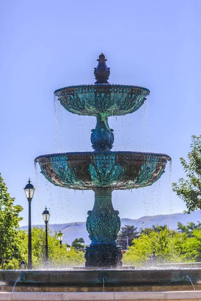 带灯的正规花园中的铜喷泉 — 图库照片