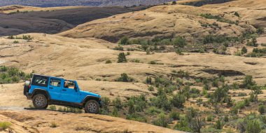 Moab, Utah içinde engebeli bir arazi üzerinde mavi araç