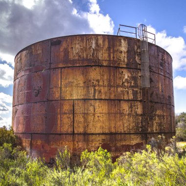 Bulutlar ve gökyüzü altında harap tank