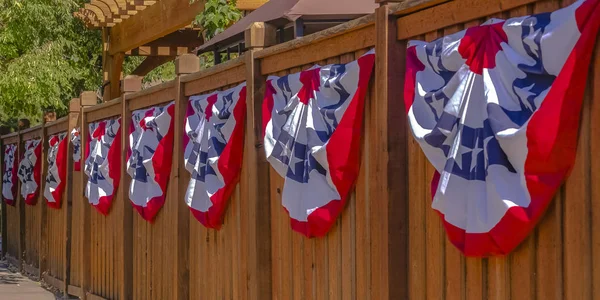 Patriotic flags hung on a wooden fence