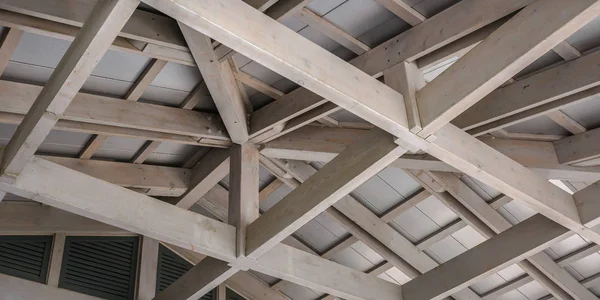 White wood ceiling framework against a white roof