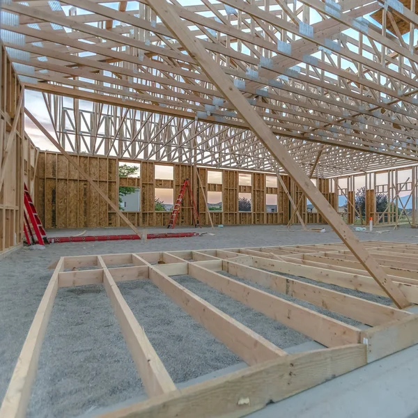 Construction yard, site, zone in Utah Valley summer 2018 with wooden beams and skeletal, scaffolding, framework structure of new buildings being constructed. viewed late day near sunset.