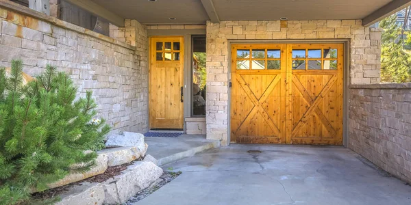 Entrée de garage avec portes en bois en brique de pierre pano — Photo
