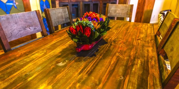 Table en bois à l'intérieur avec pot de fleurs centre pano — Photo