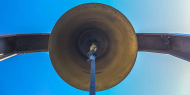 Mavi gökyüzü altında mavi ip ile Bronz çan