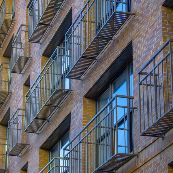 Enge und luftige Balkone eines Backsteingebäudes — Stockfoto