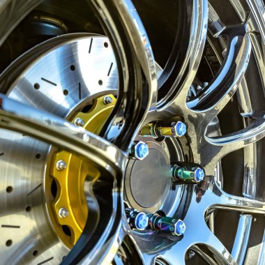 Gümüş bir araba tekerleği kenarında mavi cıvata kapaklar