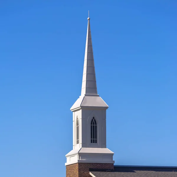 Steeple con ventanas arqueadas contra el cielo azul — Foto de Stock