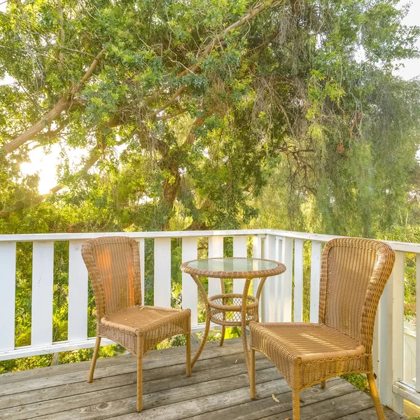 Balcon ensoleillé avec chaises et table boisées — Photo