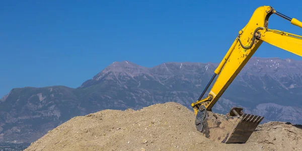 Heavy duty construction vehicle scooping up dirt — Stock Photo, Image