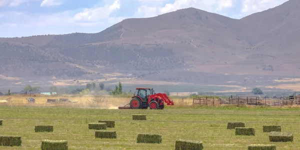 Red tractor on a field with view of mountain — Stock Photo, Image