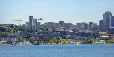 Float uçak göl ve gökdelenler üzerinde uçan