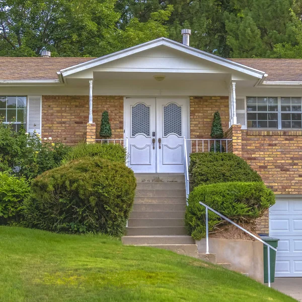 Casa de ladrillo con escaleras y puertas delanteras dobles — Foto de Stock